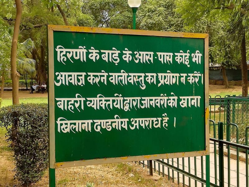 Schrift in Hindi auf einem Schild im Park